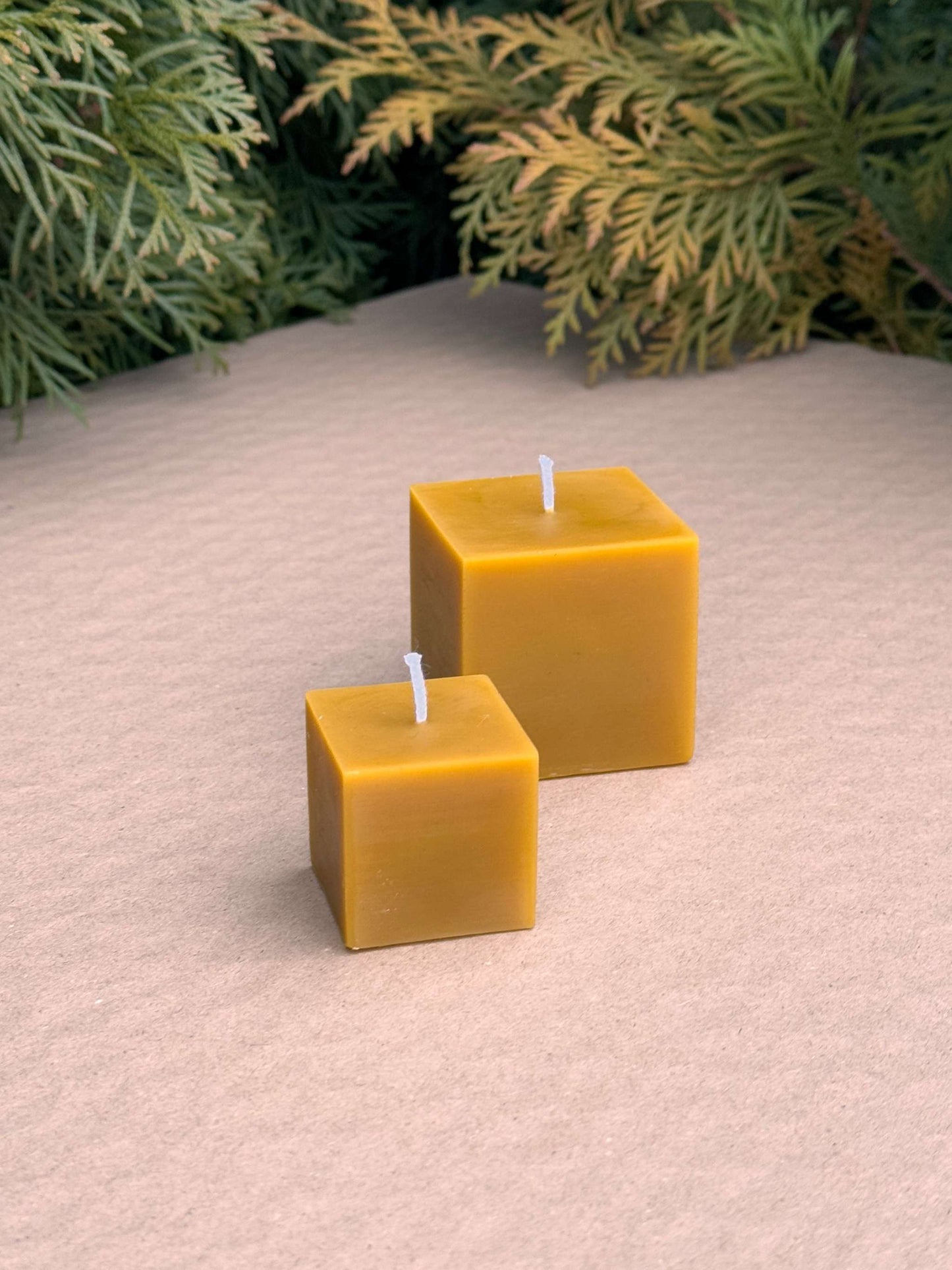 Small and medium CUTE CUBES silicone candle molds on textured surface.