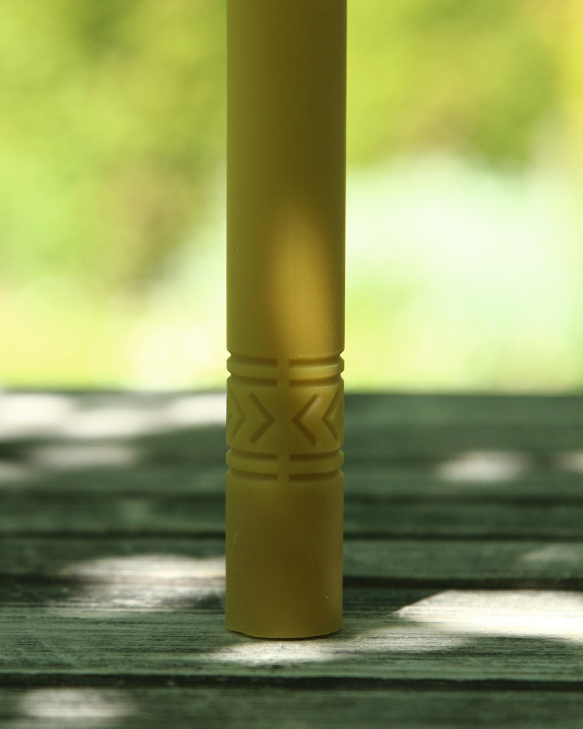 Geometric folk signs candle close-up of a cross-style motif near the base