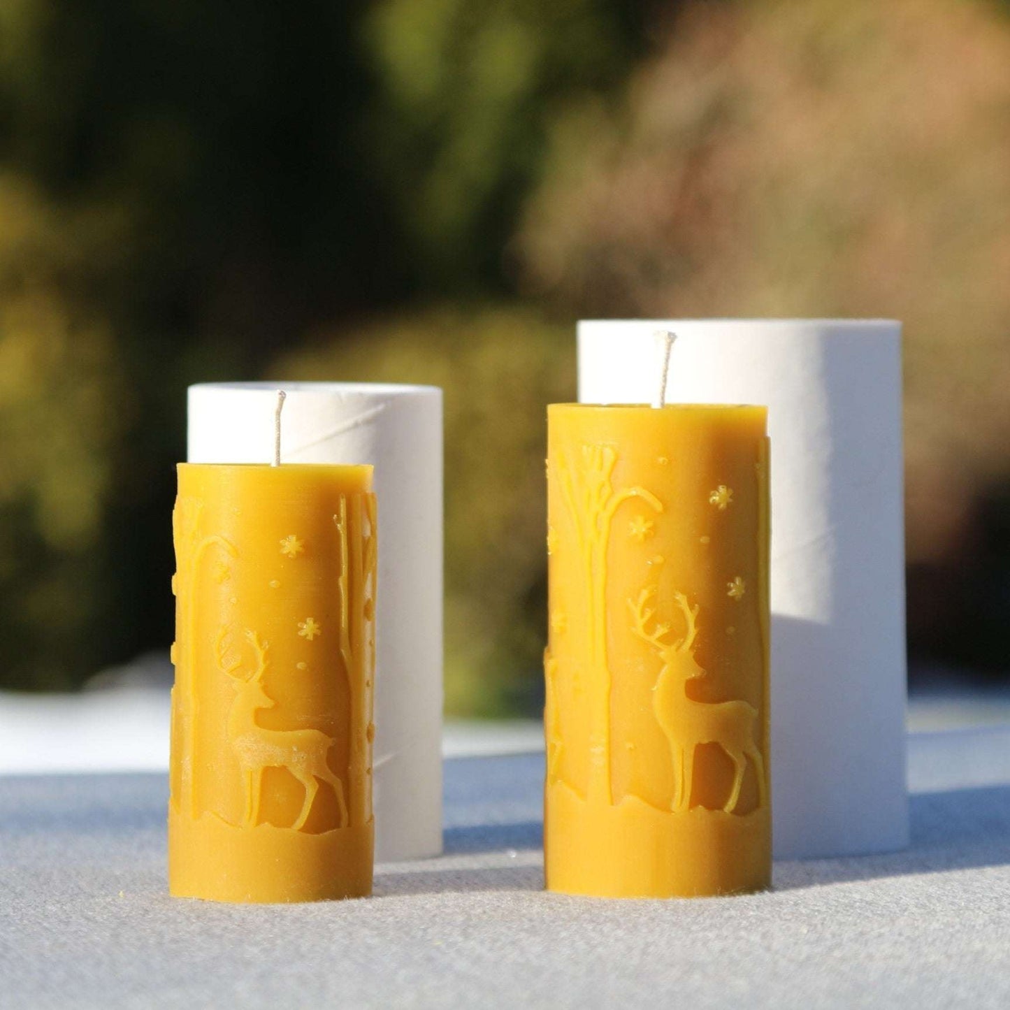 Small and big deer candles made with DEERS silicone candle mold, featuring trees and snowflakes, on display.