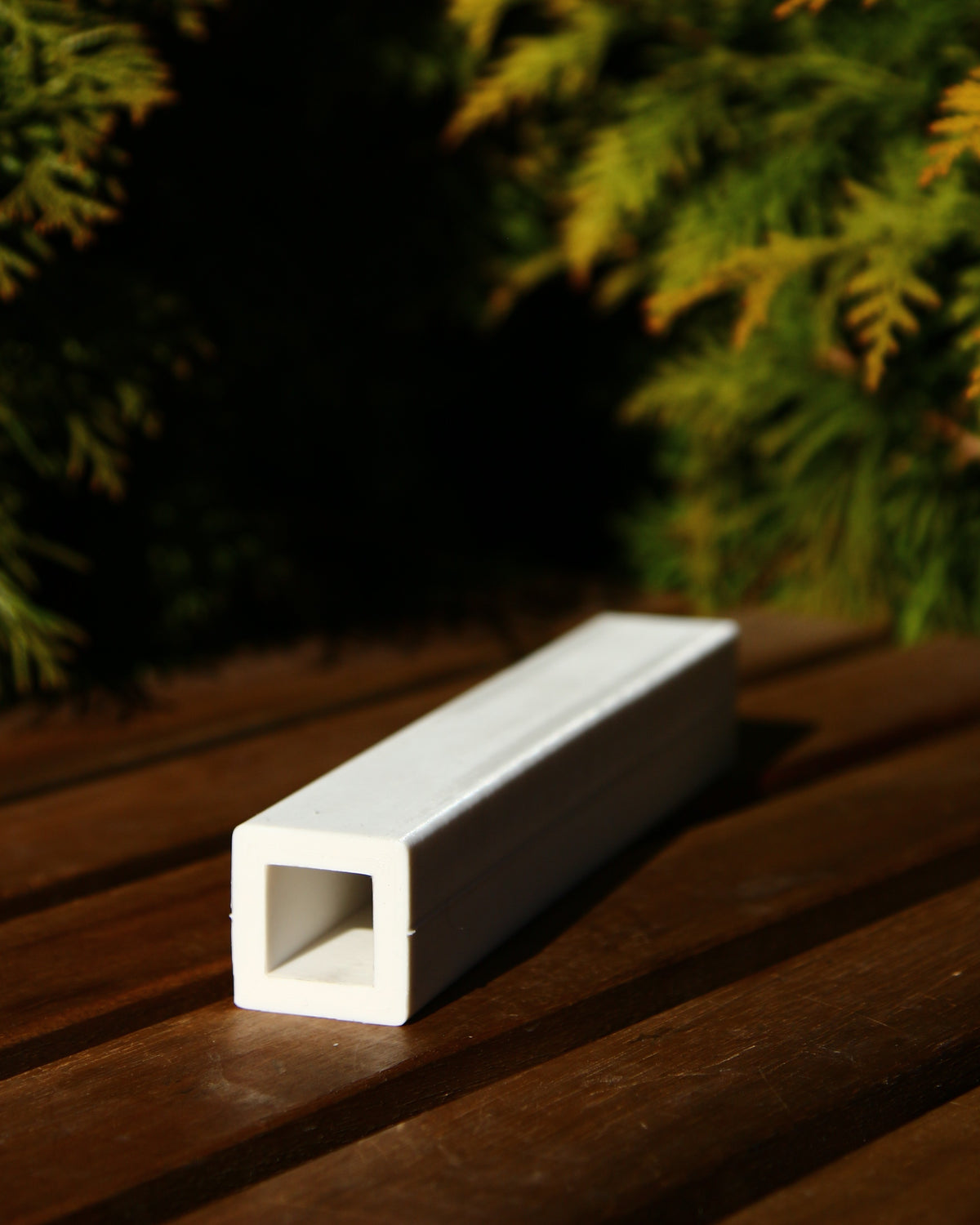 Finished beeswax candle with a slim, tapered obelisk form