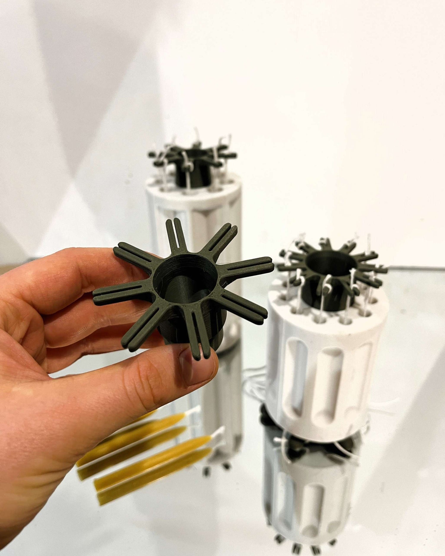 Metal wick holder positioned on candle mold