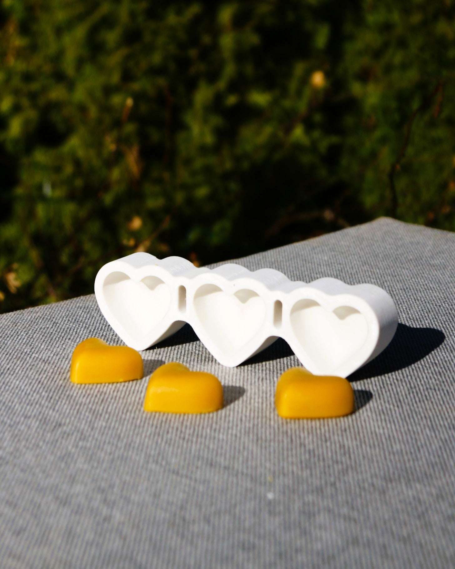 Side view of beeswax candle with floating hearts