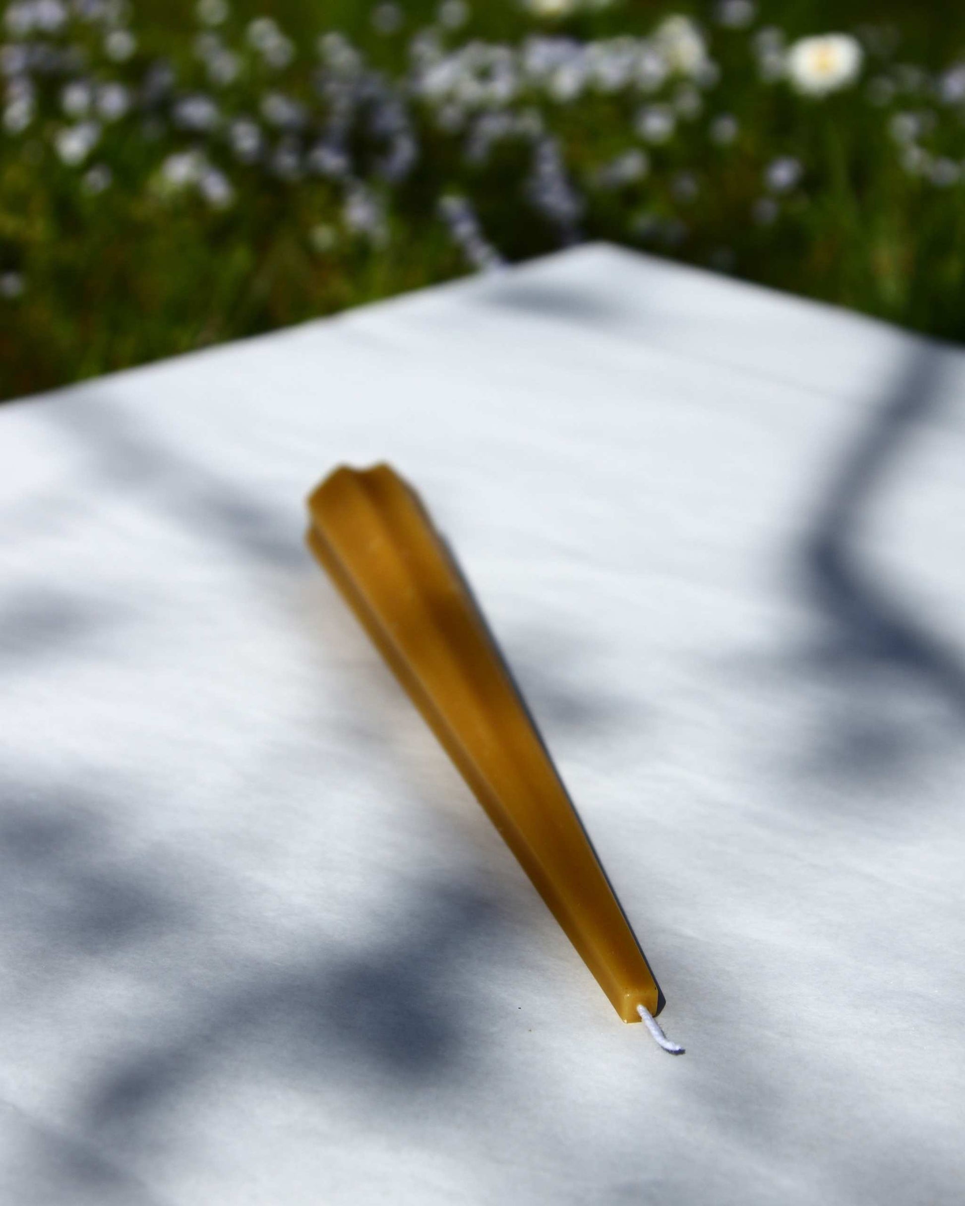 Machu Picchu Taper candle on white surface outdoors, 7.87 inches tall, 1.10 inches wide.