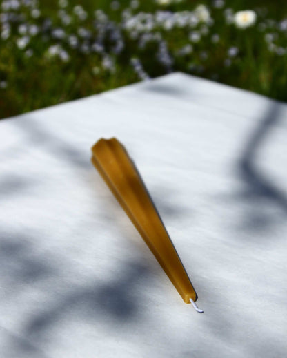 Machu Picchu Taper candle on white surface outdoors, 7.87 inches tall, 1.10 inches wide.