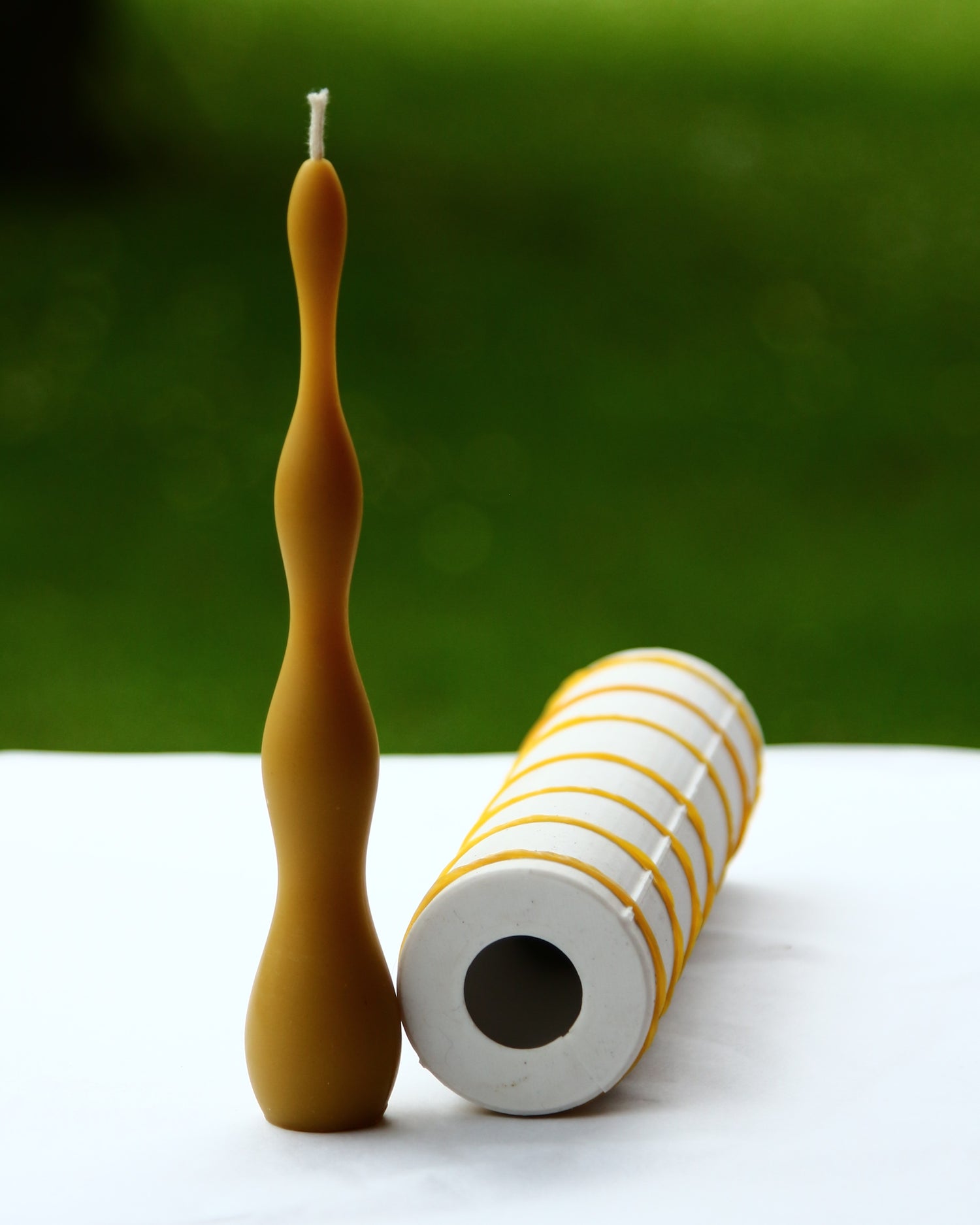 Beeswax candle with flowing wave-like surface pattern