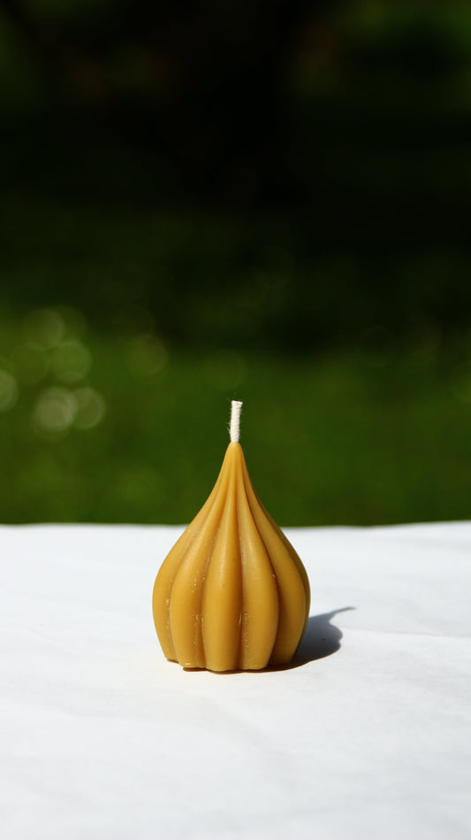 Small garlic-shaped candle made from silicone mold with natural brown color