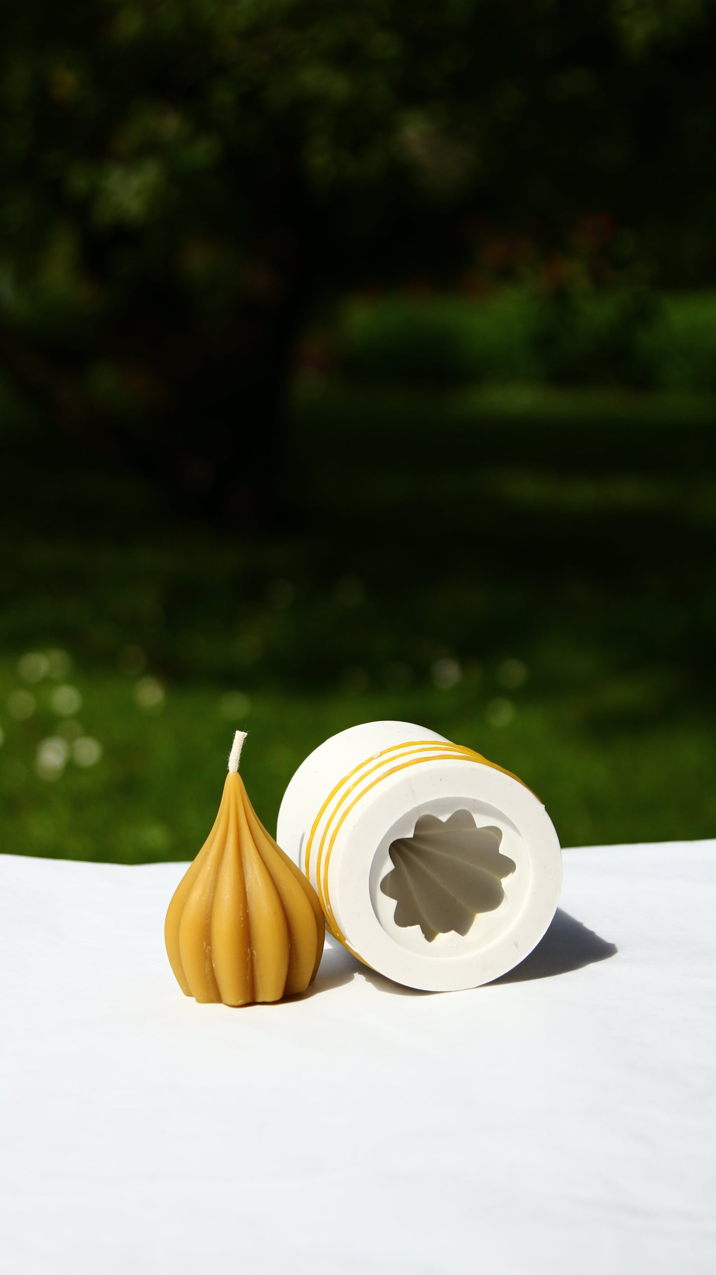 GARLIC silicone candle mold with small garlic-shaped candle and hollow mold on white surface outdoors
