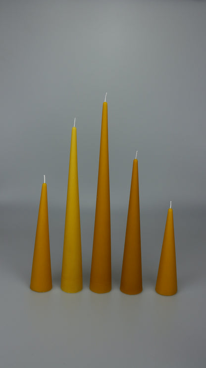 Beeswax cone candles in five heights arranged in a row