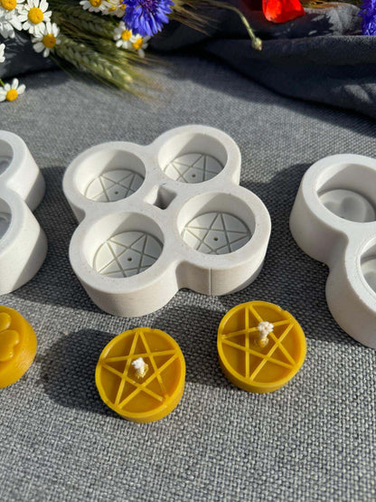 Star tea lights beeswax candles with a star pattern in front of their multi-cavity silicone moulds