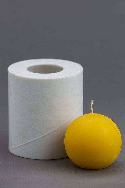 Finished round beeswax candle on grey background