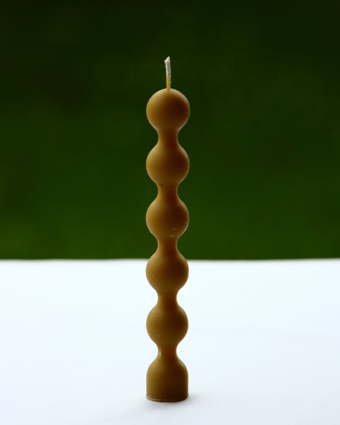Finished beeswax candle composed of stacked bead forms