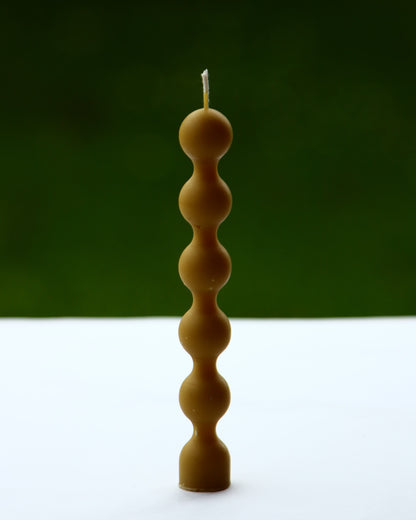 Finished beeswax candle composed of stacked bead forms