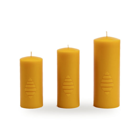 Three Pillars beeswax candles in different sizes with a small motif on white